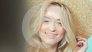 Girl in a straw hat looking at camera. Model poses to the photographer