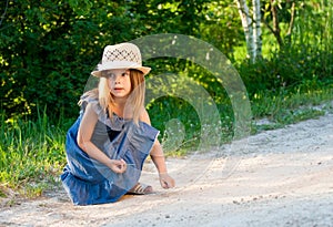Girl in straw hat playing.