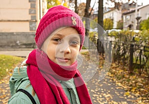 Girl on  street in autumn in  hat and scarf