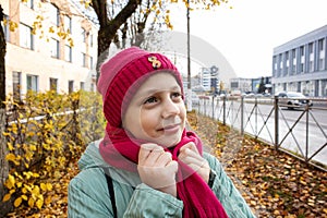 Girl on  street in autumn in  hat and scarf