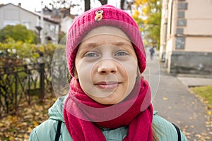 Girl on  street in autumn in  hat and scarf