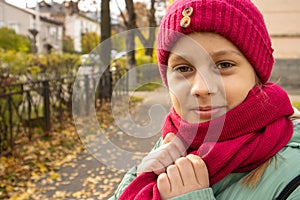 Girl on  street in autumn in  hat and scarf
