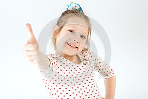 The girl stretches out her hand and shows her thumb up