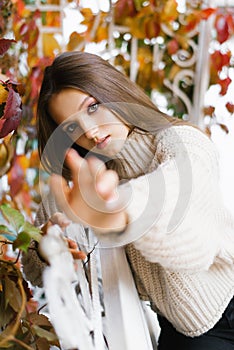 The girl stretches out her hand to the camera, the focus on the hand. Autumn weather. Come with me