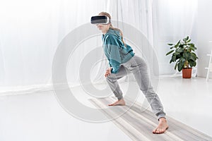 girl stretching legs with vr headset on yoga mat