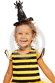 Girl in striped bee costume wearing spider hat