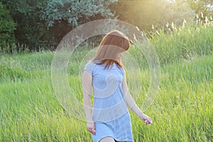 Girl in striped dress in nature at sunset