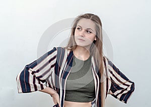 Girl in a striped jacket looks up, pensive look