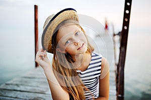 Girl in striped vest and a straw hat against the sea