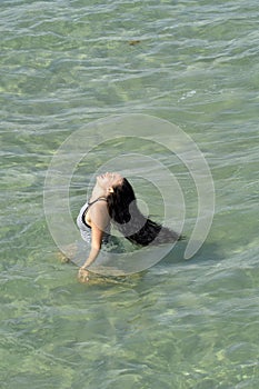 A Girl in stripped dress walking through the water
