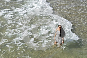 A Girl in stripped dress walking through the water