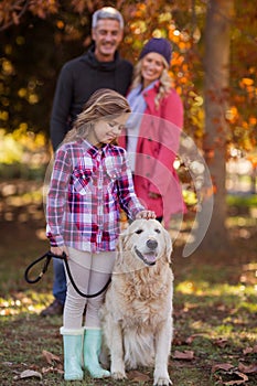 Girl stroking dog while parents at park