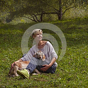 Girl stroking a goat on the grass