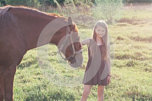 Girl stroking her horse and looking at the camera