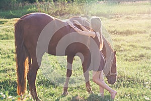 Girl stroking her horse and looking at the camera