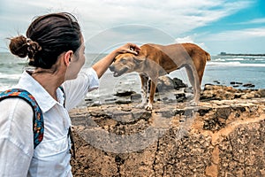 Girl stroking a homeless red dog