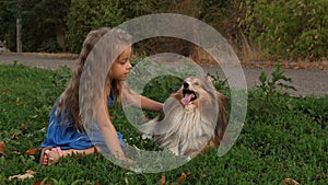 Girl stroking and hugging favorite pet Sheltie dog