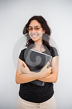 Girl student with a black paper notebook. Calm happy school girl isolated