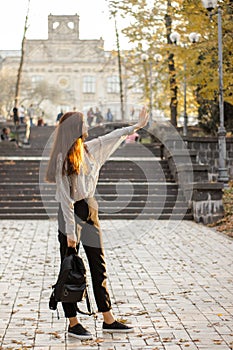 A girl student near the university closes a hand sunlight, which passes through the fingers on the arm