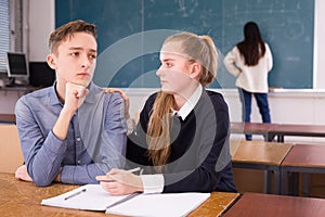 Girl student supporting upset friend in classroom