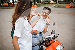 A girl student threatens a geeky boy on a motorbike