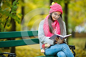 Girl students read book in yellow autumn park