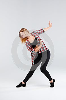 Girl in studio performs dance element isolated on white background