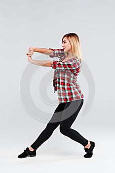 Girl in studio performs dance element isolated on white background