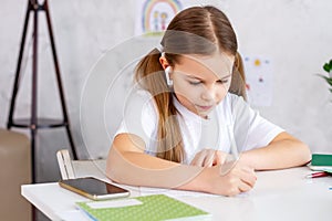 Girl study at home watching online school lessons.