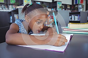 Girl studying at desk in library