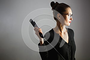 Girl stylist holding a Curling iron for hair. White isolated background