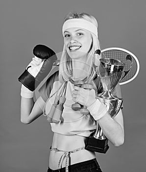 Girl successful modern woman hold golden goblet of champion. Woman good in tennis jumping boxing fitness sport. How to