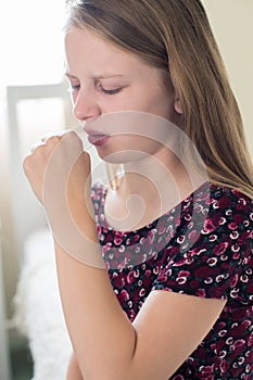 Girl Suffering With Cough Sits On Bed At Home photo