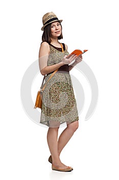 Girl in summer dress and hat holding guidebook photo
