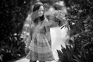 A girl in a summer dress in the park. Black and whaite photo.