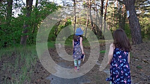 Girl in a summer dress runs in a pine forest