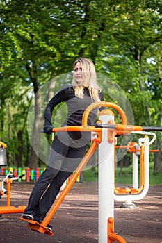 The girl on the summer sports ground does sports exercises on the stepper. Healthy lifestyle