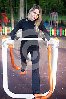 The girl on the summer sports ground does sports exercises on the stepper. Healthy lifestyle. Athletic field