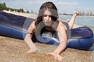 Girl sunbathing on air mattress in sea