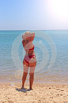 Girl sunbathing on beach during vacation. Woman enjoying relaxing at sea