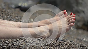 A Girl Sunbathing At The Pebbly Sea Beach