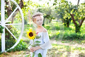Girl with sunflower. Happy child with walks in summer park. Portrait of charming little girl with a sunflower. concept of childhoo