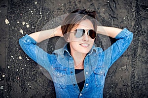 Girl with sunglasses laughing and smiling, hanging out on roof of building. Young active lifestyle people concept