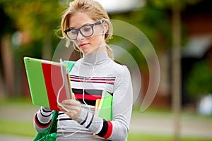 Girl in sunglasses looks in tablet computer