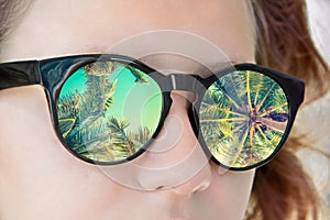 Girl sunglasses, palm trees reflection, summer concept