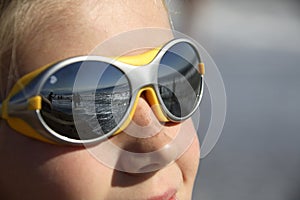 Girl with sunglasses (reflecting the beach)
