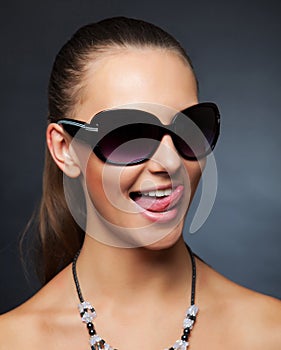Girl with sunglasses showing her tongue