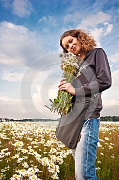 Girl in sunny field with camomiles