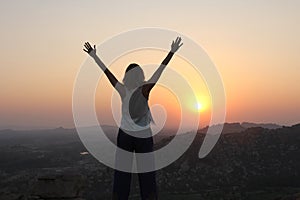 The girl at sunset. The girl stands with her back on the top of