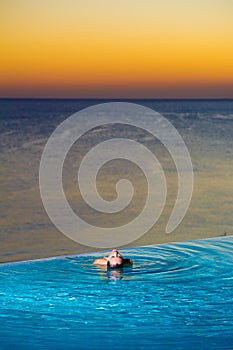 Girl in Sunset infinity pool